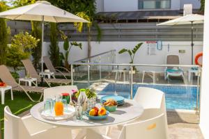 a table with fruit on it next to a pool at Accomoteleia Blue Villa in Protaras