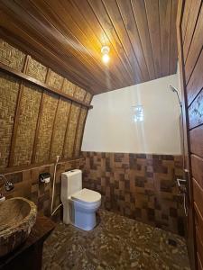a bathroom with a toilet and a sink at Volcano Cabins in Kubupenlokan
