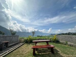 a wooden bench sitting on top of a field at Volcano Cabins in Kubupenlokan