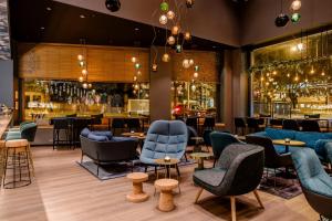 a restaurant with blue chairs and tables and a bar at Motel One Wiesbaden in Wiesbaden