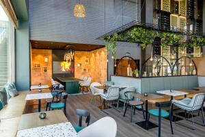 un restaurant avec des tables et des chaises ainsi qu'un bar dans l'établissement Motel One Wiesbaden, à Wiesbaden