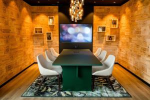 una sala de conferencias con una mesa verde y sillas blancas en Motel One Wiesbaden, en Wiesbaden