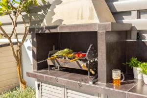 a barbecue grill on a counter with a drink at Accomoteleia Blue Villa in Protaras