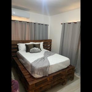 a bed in a room with a wooden bed frame at Apartment center of puerto plata in San Felipe de Puerto Plata