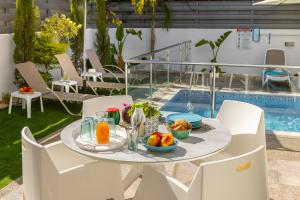 a table with food on it next to a pool at Accomoteleia Blue Villa in Protaras