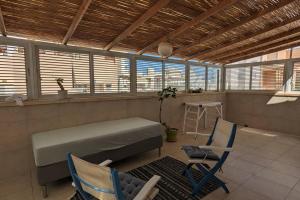 a room with a bed and two chairs and a table at rooftop studio 70 meters in Netanya