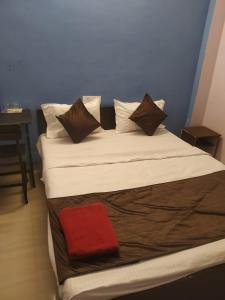 Hotel sambhodhi palace في بوبال: سرير كبير عليه منشفة حمراء