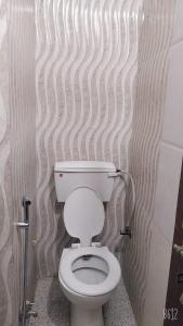 - une salle de bains avec des toilettes blanches dans une cabine dans l'établissement Hotel sambhodhi palace, à Bhopal