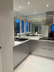 a large white kitchen with sinks and mirrors at Exclusive Comfy Apartment in Central Crans-Montana in Lens