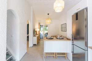a kitchen and living room with white walls and a counter at Sani Bliss by halu!, 2-BD villa with private garden in Sani Beach +23 photos