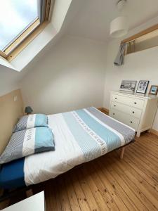ein kleines Schlafzimmer mit einem Bett und einer Kommode in der Unterkunft Spacieuse maison - Petite mer in Riantec