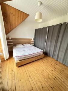 Schlafzimmer mit einem Bett und Holzboden in der Unterkunft Spacieuse maison - Petite mer in Riantec