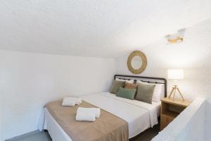 a bedroom with a bed with two pillows on it at Sani Bliss by halu!, 2-BD villa with private garden in Sani Beach