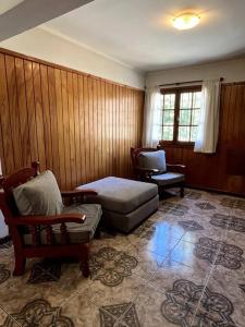 ein Wohnzimmer mit einem Bett und einem Stuhl in der Unterkunft Departamento Del Centro Primer Piso in El Bolsón