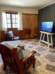 ein Wohnzimmer mit Sofa und Fernseher in der Unterkunft Departamento Del Centro Primer Piso in El Bolsón