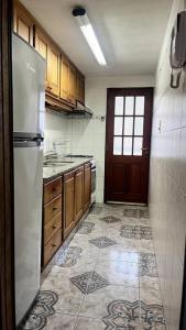 eine leere Küche mit einem Kühlschrank und einer Tür in der Unterkunft Departamento Del Centro Primer Piso in El Bolsón + 6 Fotos