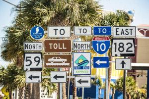 a bunch of street signs on a pole with palm trees at Great Views And Just Steps to the Beach - Moonraker #31 - Sleeps 6 in Gulf Shores +27 photos