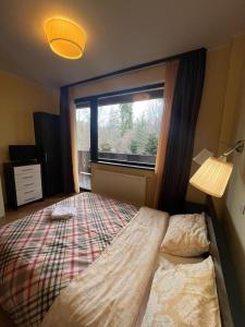 um quarto com uma cama grande e uma janela em Apartament Marcus 1 Poiana Brasov em Poiana Brasov