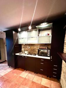 uma cozinha com armários pretos e um micro-ondas em Apartament Marcus 1 Poiana Brasov em Poiana Brasov