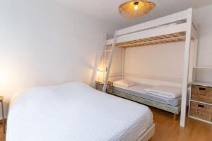 um quarto com um beliche e uma cama branca em Pleasant 3-rooms apartment for 6 people with parking space em Le Touquet-Paris-Plage