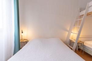um quarto com uma cama branca e uma escada em Pleasant 3-rooms apartment for 6 people with parking space em Le Touquet-Paris-Plage