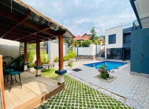 a backyard with a swimming pool and a house at LUXURYSTAY-CATION in Kigali