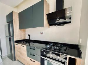 a kitchen with a black stove and a refrigerator at LUXURYSTAY-CATION in Kigali