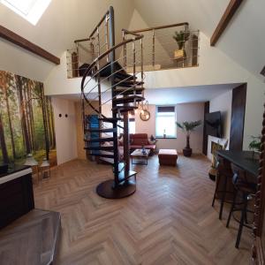 una sala de estar con una escalera de caracol en una casa en Apartament w Tucholi, en Tuchola