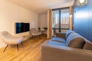 sala de estar con sofá, sillas y TV en Appartement tout confort pour 5 pers avec piscine tennis et parking REF 232, en Le Touquet-Paris-Plage