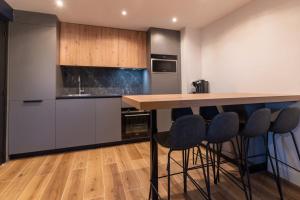 a kitchen with a counter and some blue bar stools at Appartement tout confort pour 5 pers avec piscine tennis et parking REF 232 in Le Touquet-Paris-Plage