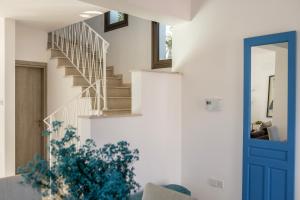 a staircase in a house with a blue door at Accomoteleia Blue Villa in Protaras