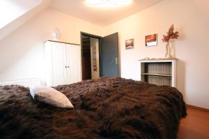 a bedroom with a brown blanket on a bed at Meerzeit in Schülp