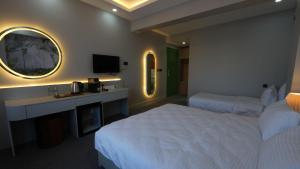ein Hotelzimmer mit 2 Betten und einem TV in der Unterkunft CARTİER LUXURY OTEL in Diyarbakır