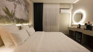 a bedroom with a white bed and a desk at CARTİER LUXURY OTEL in Diyarbakır