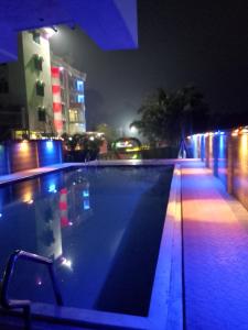 una piscina vacía por la noche con luces azules en Grand Selim Resort & Tour – GSRT, en Sreemangal