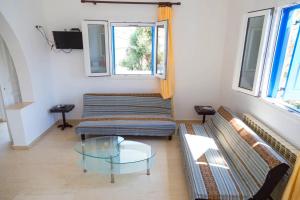 a living room with a couch and a glass table at Villa Vasilis in Mikonos
