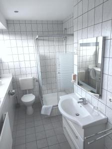 a white bathroom with a sink and a toilet at Hotel-Restaurant Ammertmann in Gronau