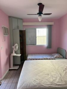 - une chambre avec 2 lits et un ventilateur de plafond dans l'établissement Apartamento 100 mt da praia em Promoção, à Florianópolis