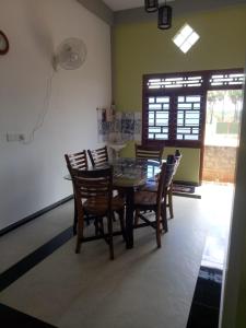 a dining room with a table and chairs and a window at Billiards villa in Trincomalee