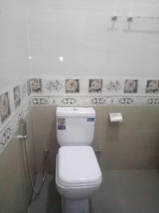 a bathroom with a toilet and pictures on the wall at Billiards villa in Trincomalee