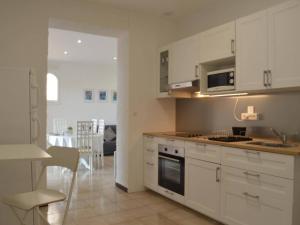 a kitchen with white cabinets and a dining room at Appartement Banyuls-sur-Mer, 3 pièces, 5 personnes - FR-1-225C-39 in Banyuls-sur-Mer