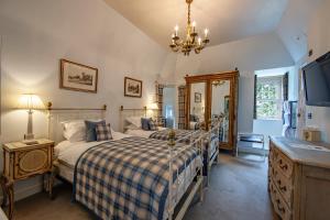 a bedroom with two beds and a television and a chandelier at Barcaldine Castle in Oban