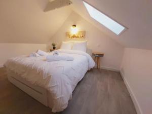 a bedroom with a large white bed with a skylight at Duplex Cosy 2 in Gouesnou