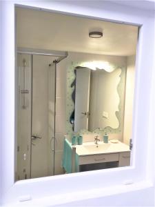 a bathroom mirror with a sink and a shower at LA CASA DEL SOL in Pego