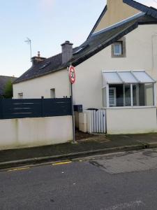 a white house with a no parking sign in front of it at Duplex Cosy 2 in Gouesnou