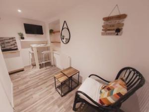 a living room with a chair and a table at Duplex Cosy 2 in Gouesnou