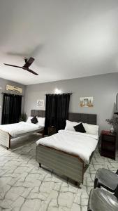a bedroom with two beds and a ceiling fan at Casa Almeida Hotel in Candolim