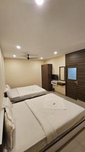 een slaapkamer met 2 bedden en een flatscreen-tv bij Heres Haut Residency in Cochin