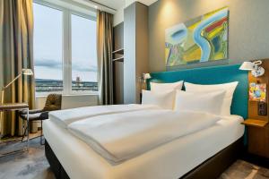a hotel room with a large bed and a window at Motel One Wiesbaden in Wiesbaden