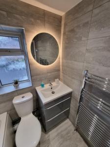 ein Badezimmer mit Toilette, Waschbecken und Spiegel in der Unterkunft Dulverton house - 3 bed house /sleeps 6+ driveway+close to M1 in Nottingham + 16 Fotos